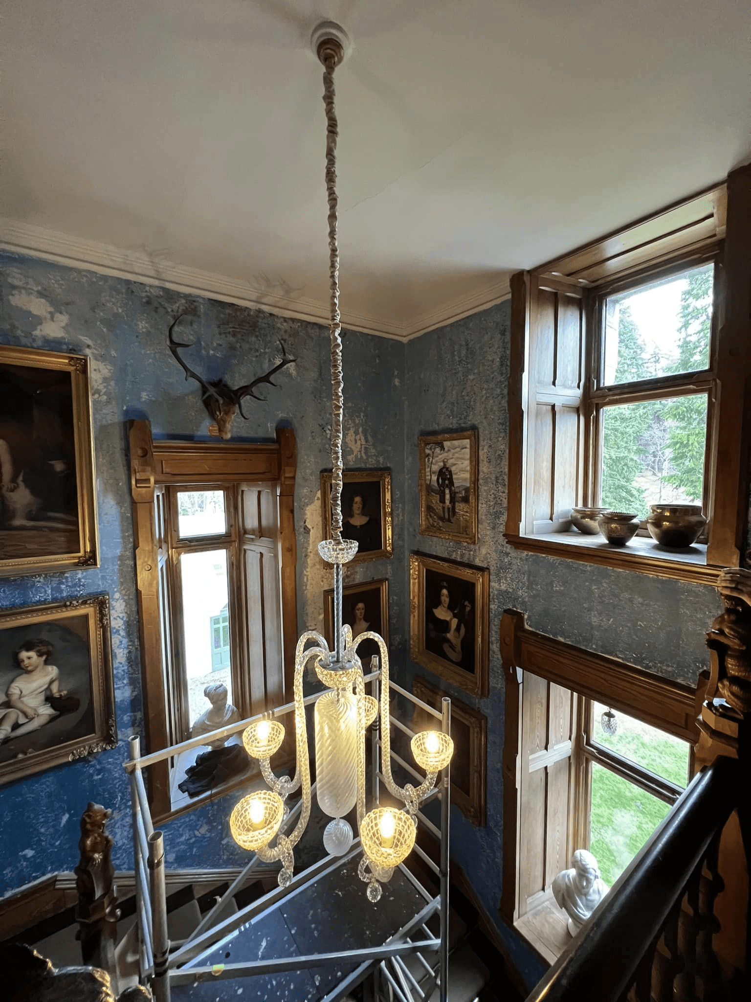 Chandelier installation in a tall interior space